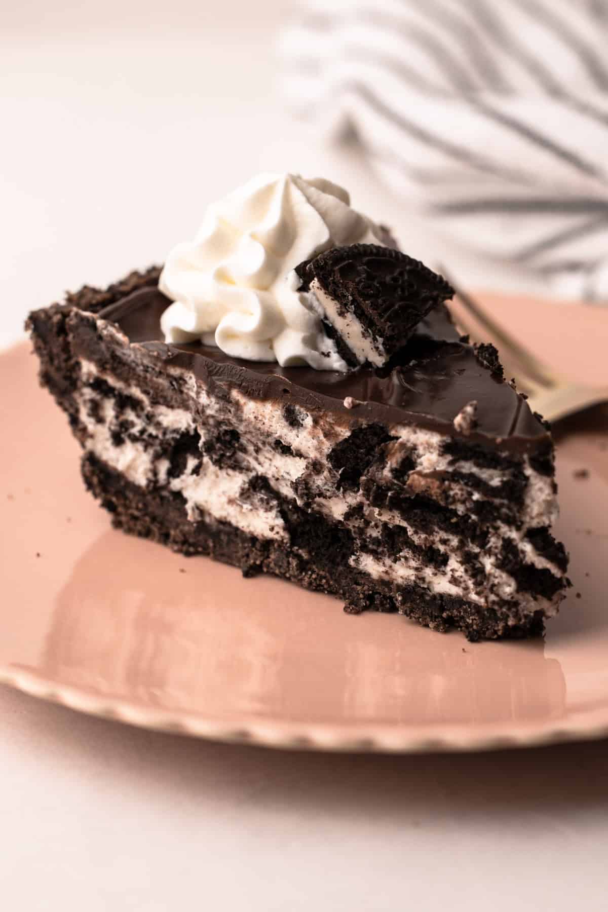 Une part de tarte Oreo sur une assiette, décorée de crème fouettée