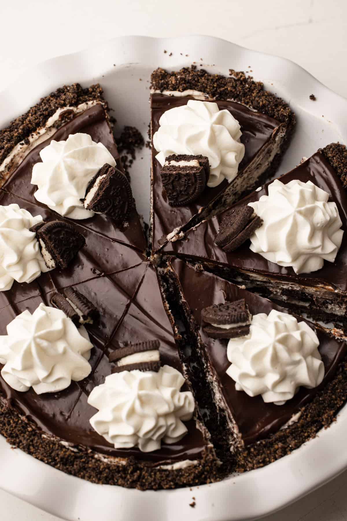Tarte Oreo entière et tranchée, décorée de ganache, Oreos et crème fouettée